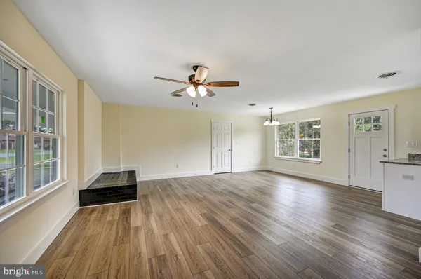 a view of a livingroom with wooden floor and a ceiling fan