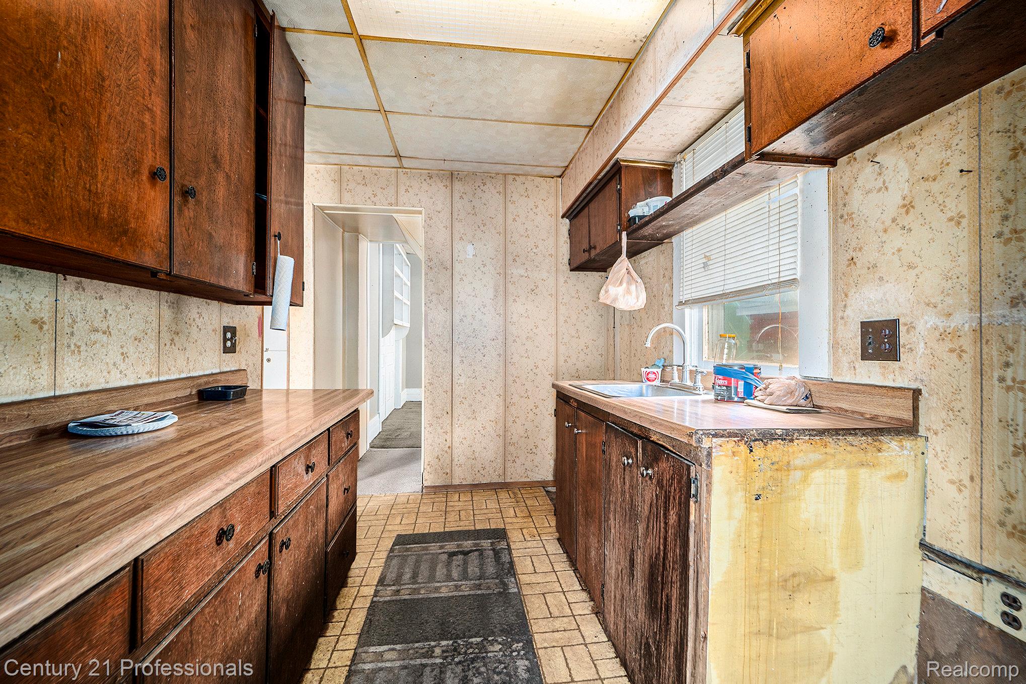 428 East Street Rochester, MI 48307 - Photo 22 of 30 Kitchen with wallpapered walls, dark brown cabinets, open shelves, and brick patterned flooring