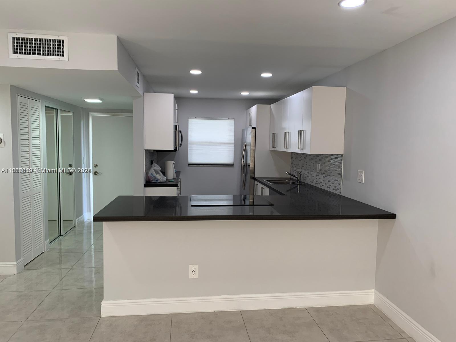a large kitchen with kitchen island a sink stainless steel appliances and cabinets