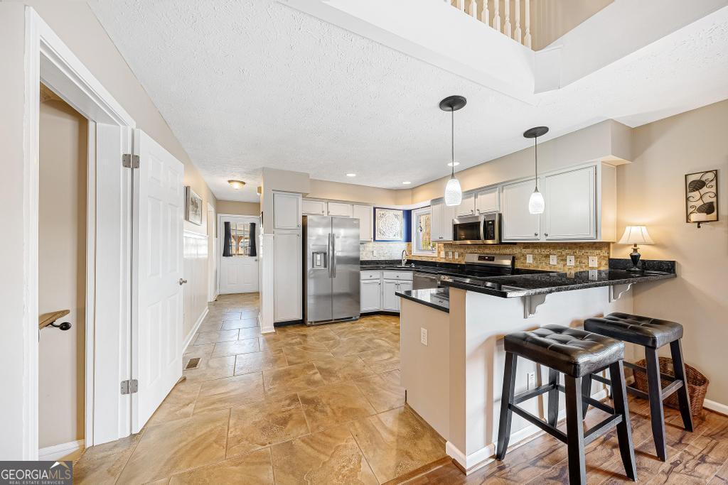 997 Rue Fluer De Lis Lavonia, GA 30553 - Photo 12 of 38 a kitchen with stainless steel appliances kitchen island granite countertop a refrigerator and a stove top oven