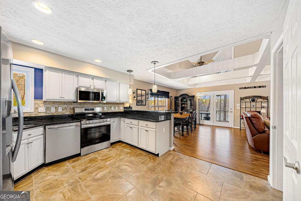 997 Rue Fluer De Lis Lavonia, GA 30553 - Photo 13 of 38 a kitchen with stainless steel appliances granite countertop a stove and cabinets