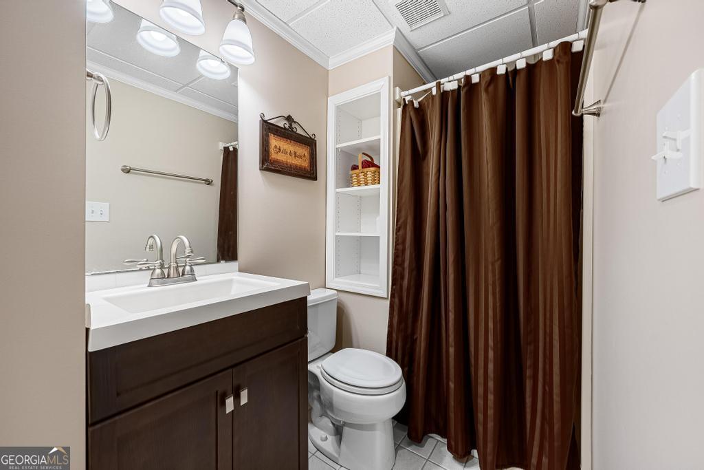 997 Rue Fluer De Lis Lavonia, GA 30553 - Photo 24 of 38 a bathroom with a sink a toilet a mirror and shower curtain