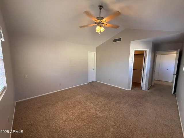 a view of an empty room with a chandelier fan