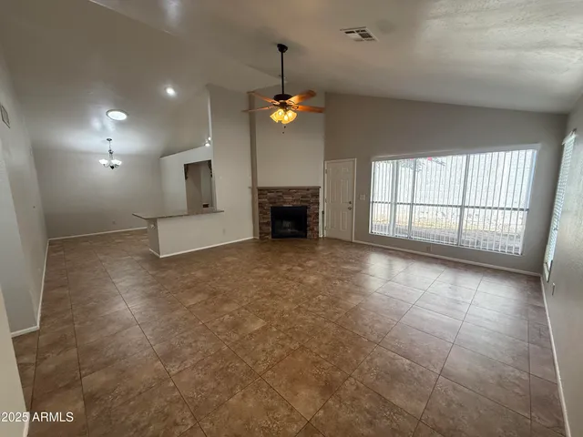 an empty room with windows and fireplace
