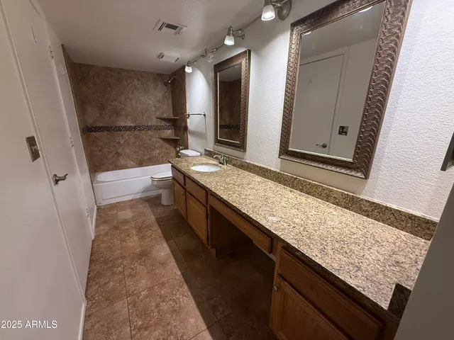a bathroom with a granite countertop sink and mirror