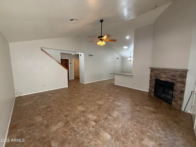 an empty room with fireplace and windows