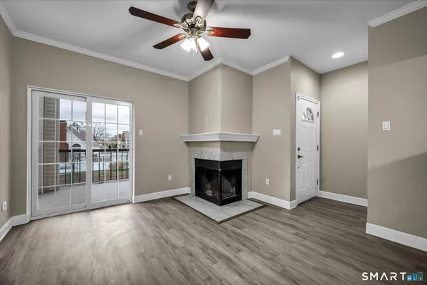 a view of a livingroom with wooden floor a fireplace and window