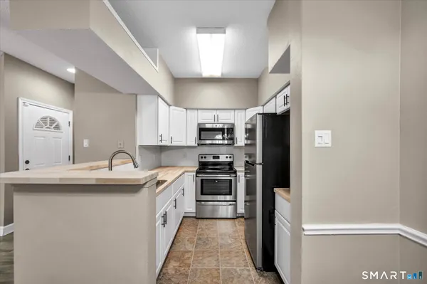 a kitchen with stainless steel appliances granite countertop a sink and a refrigerator