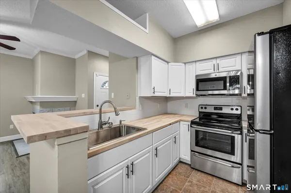 a kitchen with sink a microwave and cabinets