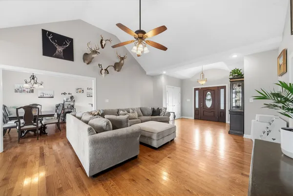 a living room with furniture kitchen view and a wooden floor