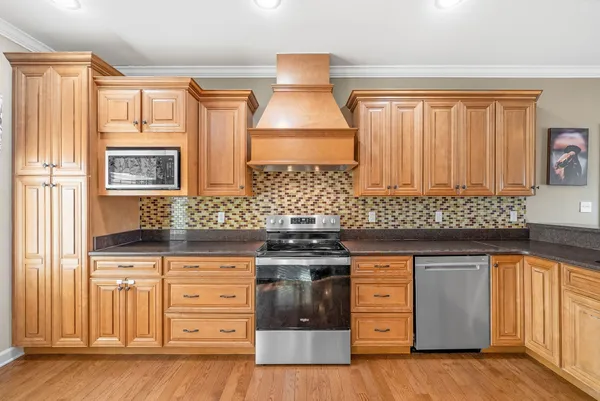 a kitchen with stainless steel appliances granite countertop a stove and a wooden cabinets