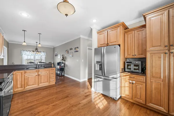 a kitchen with stainless steel appliances granite countertop a refrigerator and a stove top oven