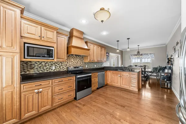 a large kitchen with stainless steel appliances granite countertop a stove and cabinets