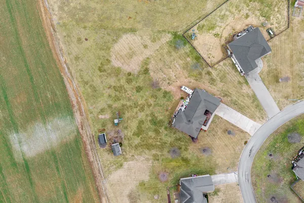 an aerial view of a house with swimming pool and lake view