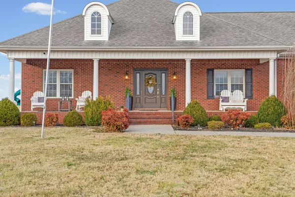 front view of a brick house with a yard