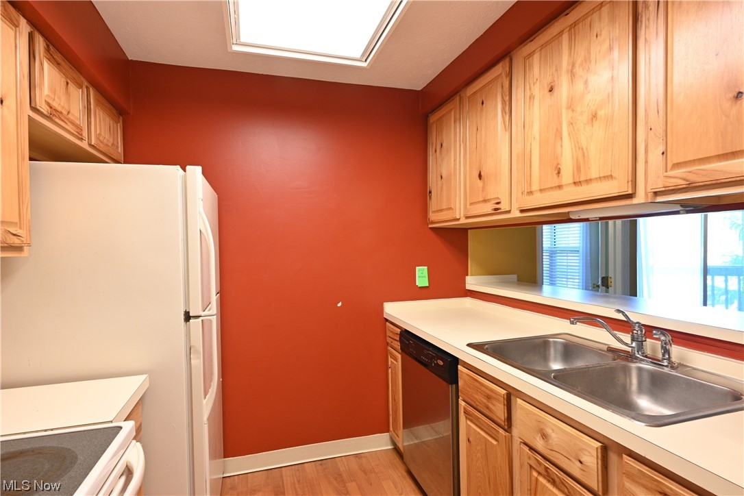 28140 Detroit Road, Unit A1 Westlake, OH 44145 - Photo 12 of 30 Kitchen featuring sink, light hardwood floors, stove, white fridge, and stainless steel dishwasher