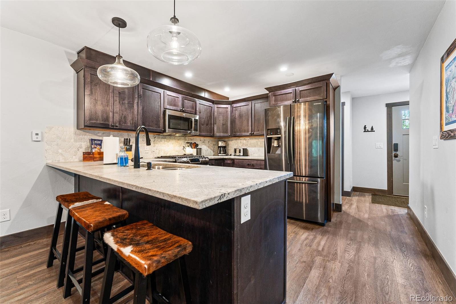 500 Vasquez Road, Unit 7A Winter Park, CO 80482 - Photo 18 of 49 a kitchen with kitchen island granite countertop a sink cabinets a refrigerator and a stove