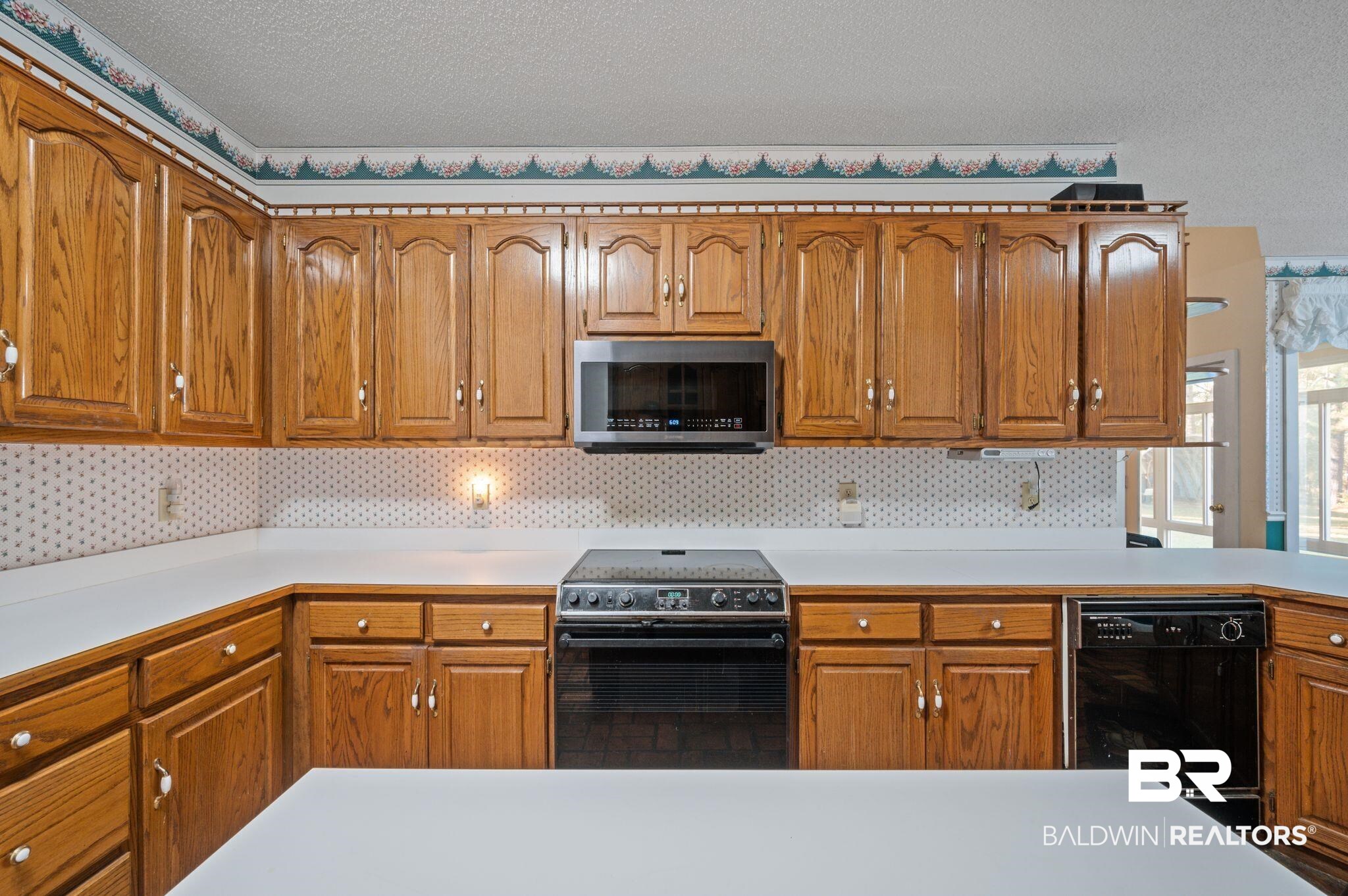 15801 Maytower Road Bay Minette, AL 36507 - Photo 19 of 43 Kitchen featuring a textured ceiling, tasteful backsplash, and black appliances