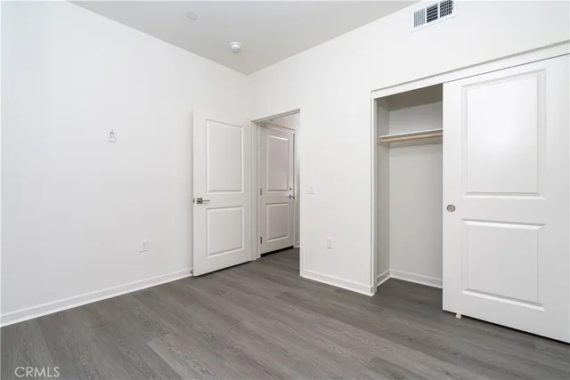 an empty room with wooden floor and closet