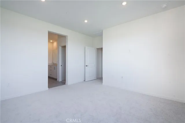 a view of a swimming pool with lawn chairs and large trees