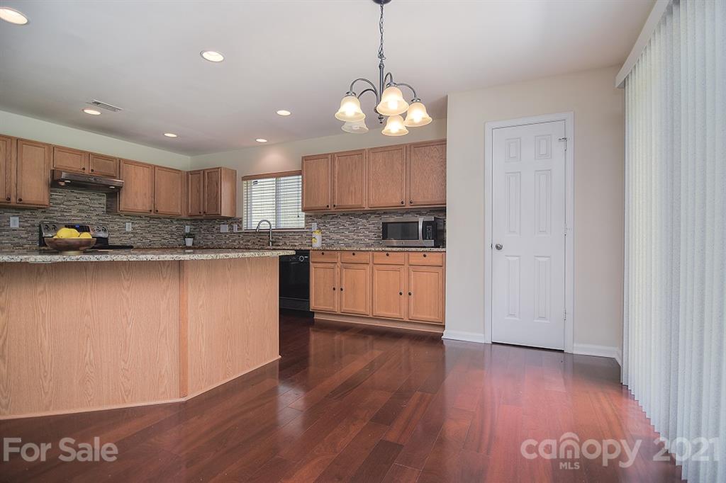 9029 Seamill Road Charlotte, NC 28278 - Photo 12 of 46 a kitchen with stainless steel appliances granite countertop a stove a sink dishwasher and a refrigerator with wooden floor