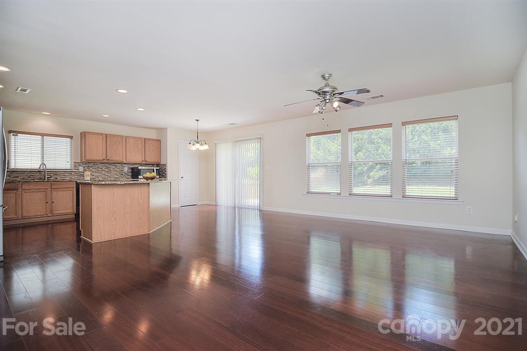 9029 Seamill Road Charlotte, NC 28278 - Photo 14 of 46 a view of an empty room with wooden floor and a kitchen