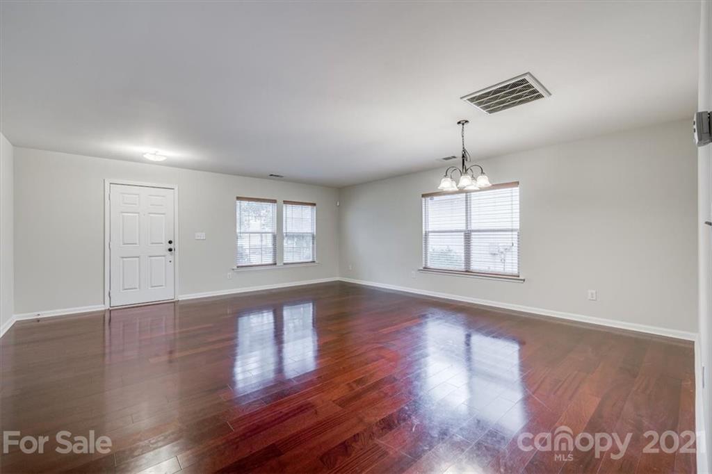 9029 Seamill Road Charlotte, NC 28278 - Photo 3 of 46 a view of an empty room with wooden floor and a window