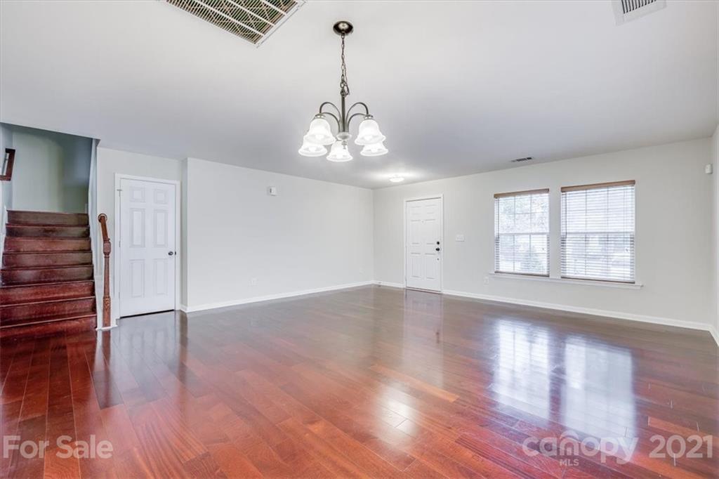 9029 Seamill Road Charlotte, NC 28278 - Photo 5 of 46 a view of an empty room with wooden floor and a window