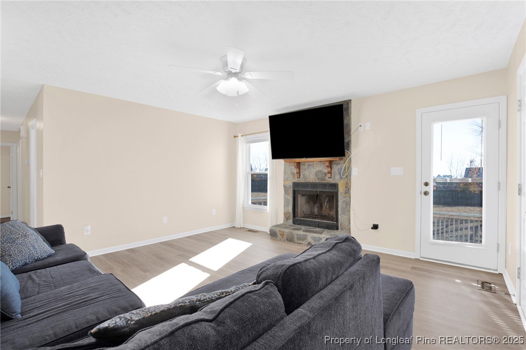 101 2 Hours Court Raeford, NC 28376 - Photo 7 of 30 a living room with furniture a fireplace and a flat screen tv