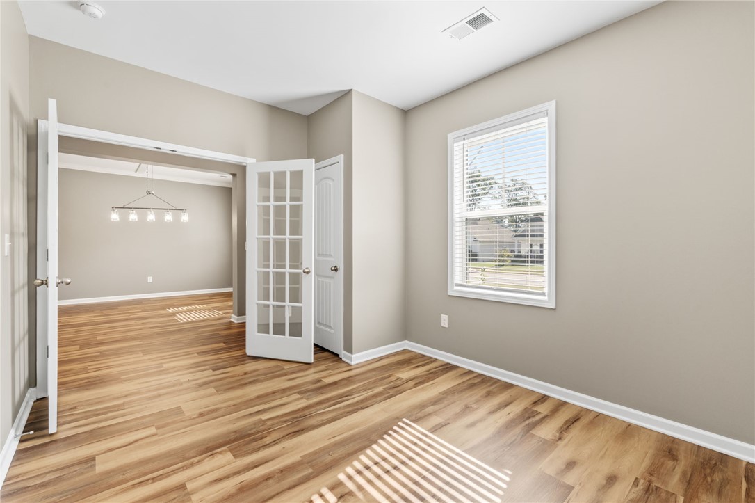 127 Spyglass Lane Pendleton, SC 29670 - Photo 12 of 45 Double glass doors open into a versatile home office space with rich wood-style flooring.
