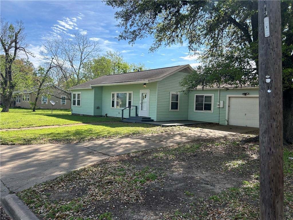 369 7th Street Somerville, TX 77879 - Photo 1 of 1 Ranch-style house with a front yard and a garage