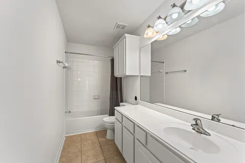 an empty room with windows and chandelier fan