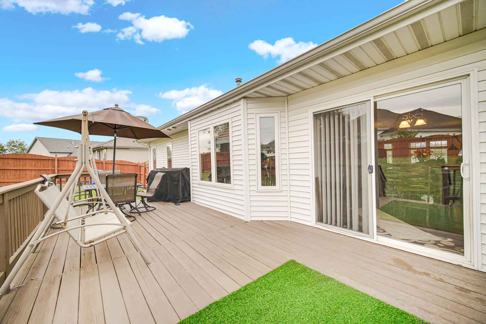 1055 Doe Path Lane Crown Point, IN 46307 - Photo 12 of 26 a view of a patio with table and chairs under an umbrella with wooden floor