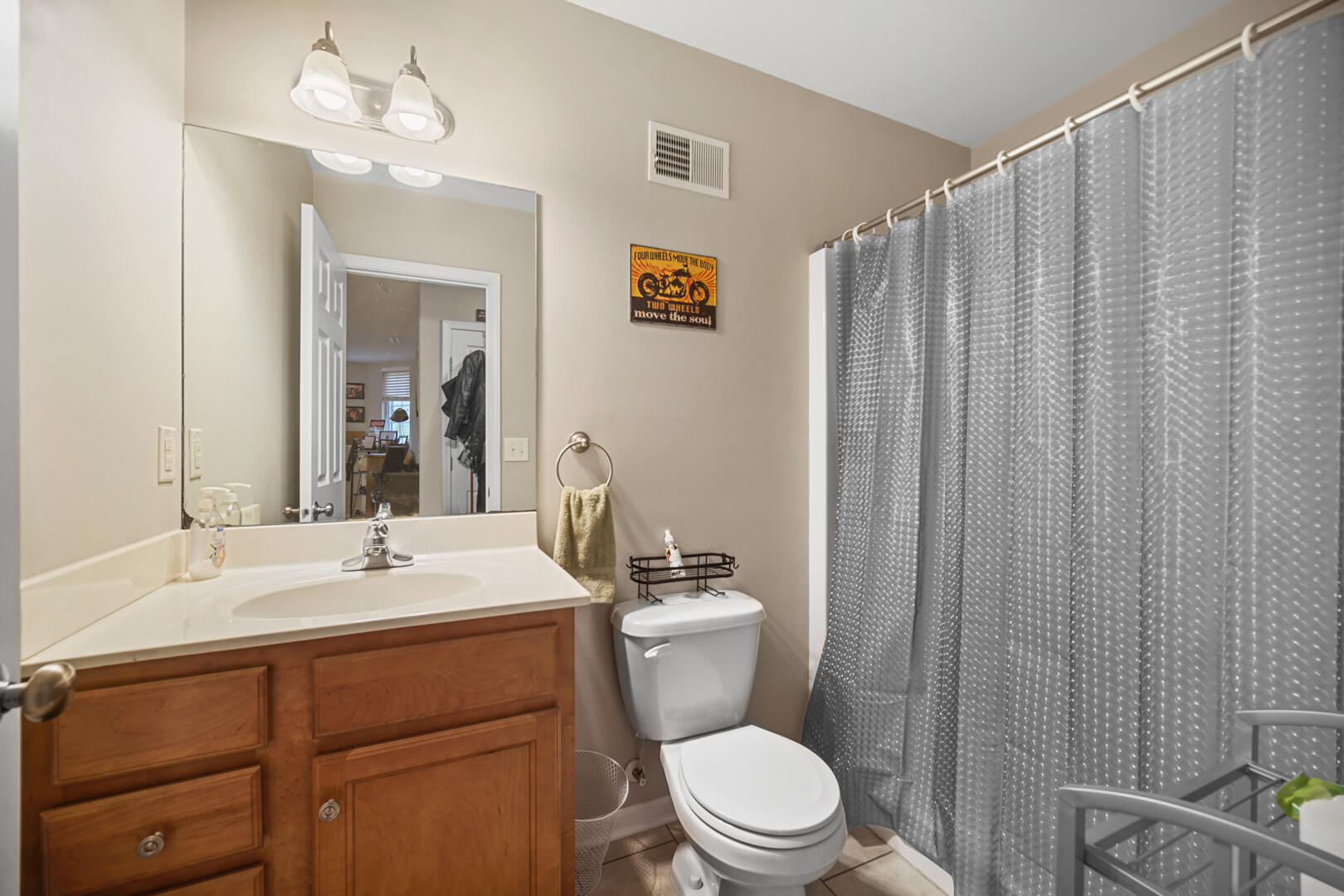 1055 Doe Path Lane Crown Point, IN 46307 - Photo 25 of 26 a bathroom with a sink a toilet a mirror and shower curtain