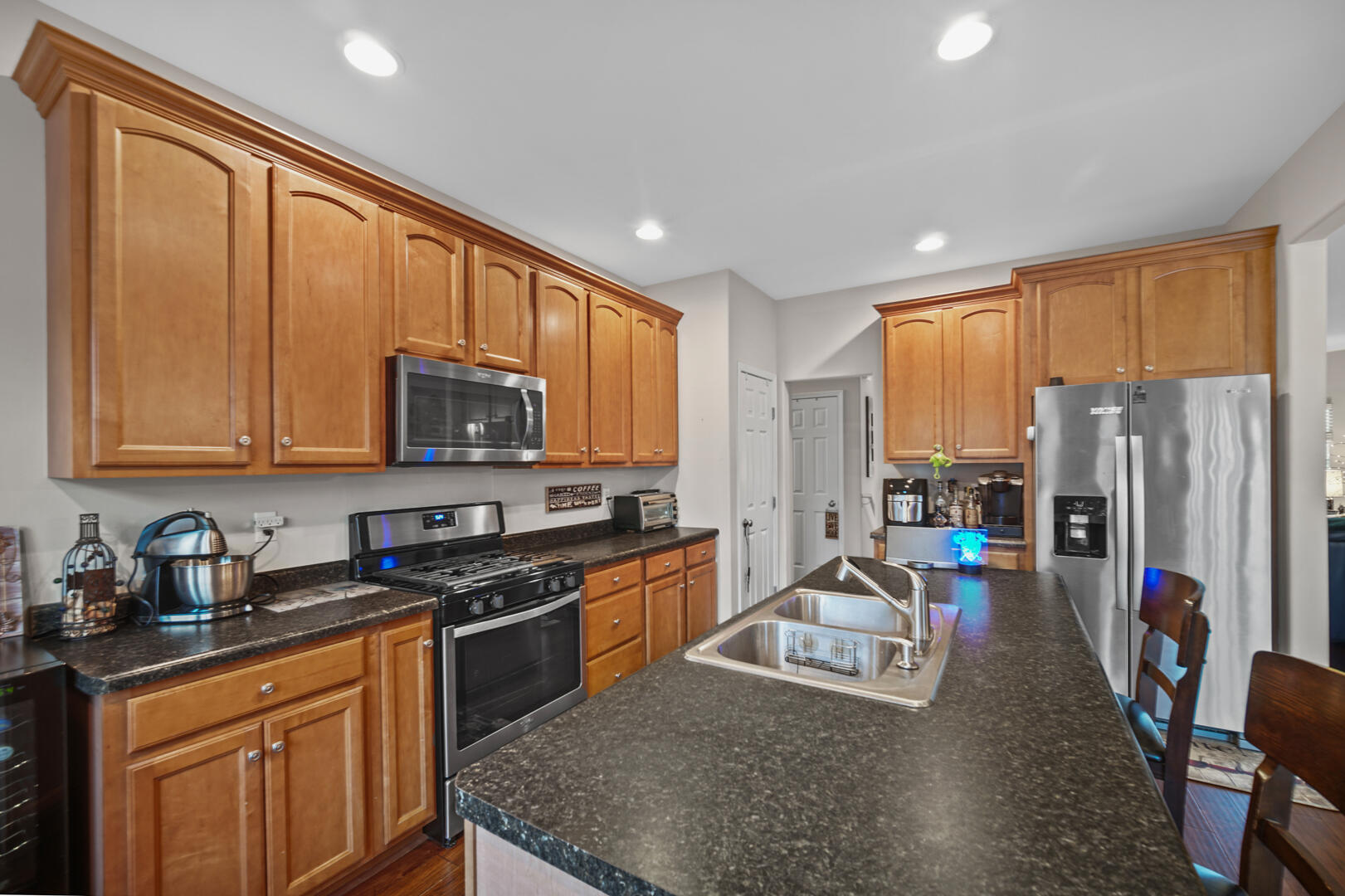 1055 Doe Path Lane Crown Point, IN 46307 - Photo 6 of 26 a kitchen with stainless steel appliances granite countertop a stove top oven a sink dishwasher a refrigerator and cabinets with wooden floor