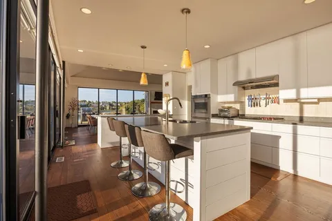 a kitchen with stainless steel appliances kitchen island granite countertop a stove a sink and a refrigerator