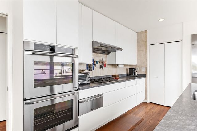 a kitchen with granite countertop a refrigerator stove and sink