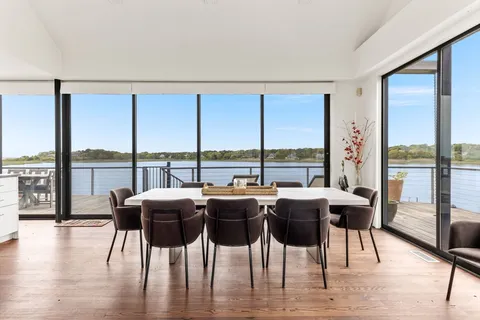 a dining room with furniture window and wooden floor