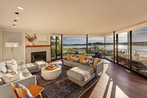 a living room with furniture large windows and a fireplace