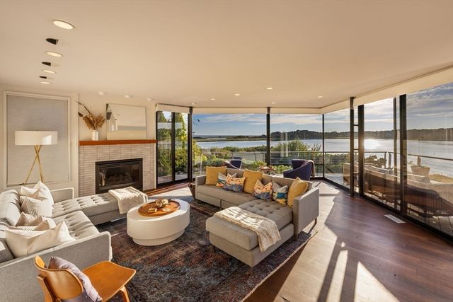a living room with furniture large windows and a fireplace