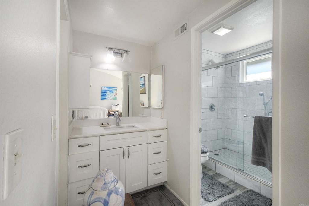 4413 Point Degada Oceanside, CA 92058 - Photo 22 of 46 a bathroom with a shower sink and mirror