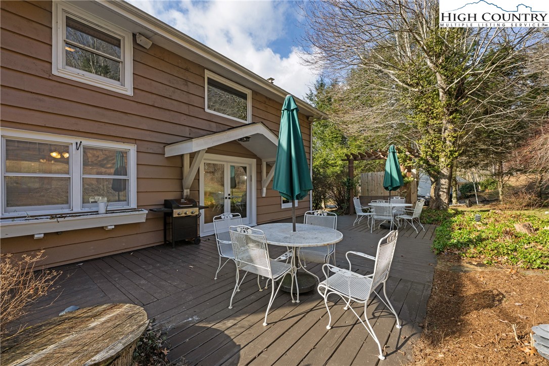 211 Possum Hollow Road Blowing Rock, NC 28605 - Photo 36 of 46 a view of a patio with table and chairs with wooden floor and fence