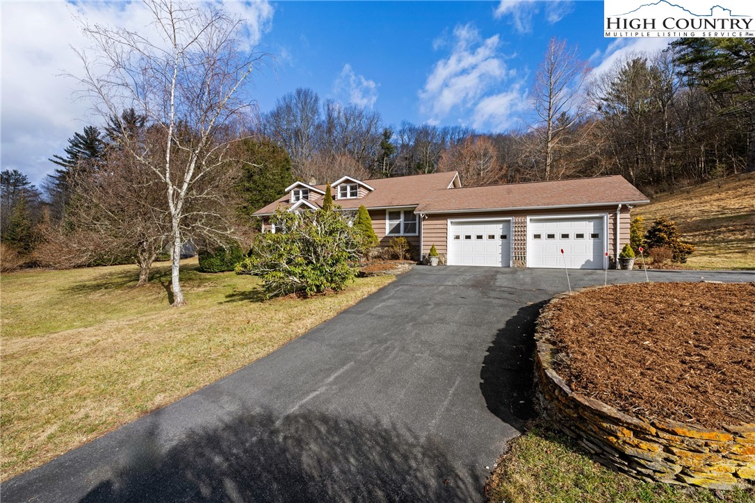 211 Possum Hollow Road Blowing Rock, NC 28605 - Photo 45 of 46 a view of a white house with a yard covered with snow in front of house