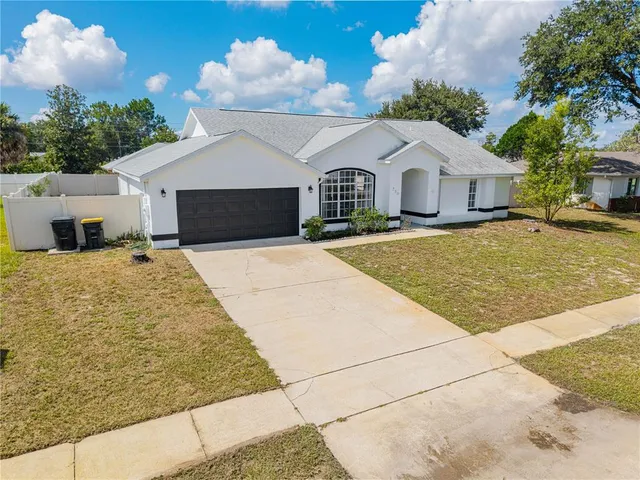 a view of a white house with yard and plants