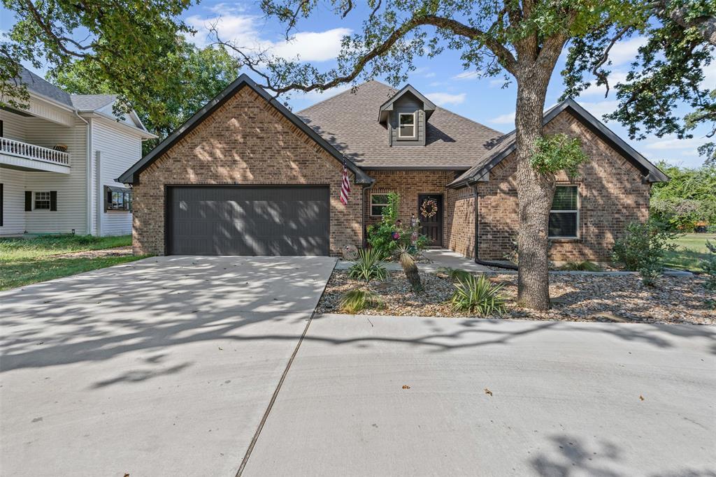 204 West 5th Street Springtown, TX 76082 - Photo 1 of 28 a front view of a house with garden