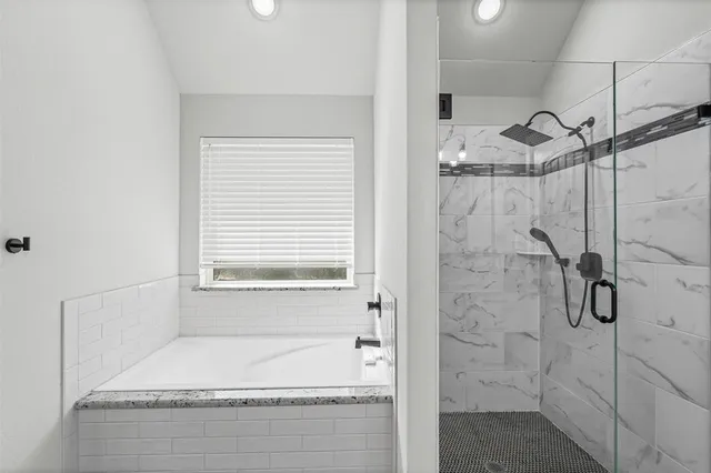 a bathroom with a bathtub and shower