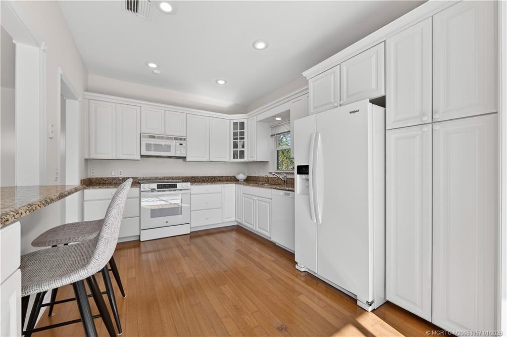 12400 Harbour Ridge Boulevard, Unit 58 Palm City, FL 34990 - Photo 17 of 42 a kitchen with white cabinets and stainless steel appliances