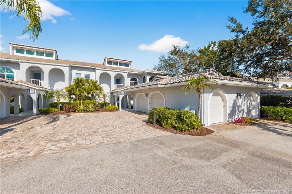 12400 Harbour Ridge Boulevard, Unit 58 Palm City, FL 34990 - Photo 31 of 42 a front view of a house with a yard and garage