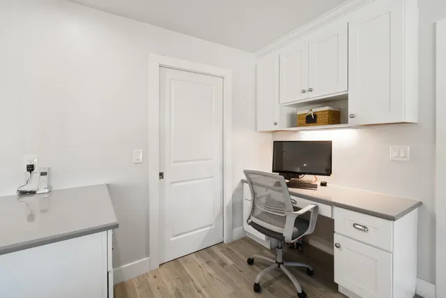 a view of a workspace with furniture and wooden floor