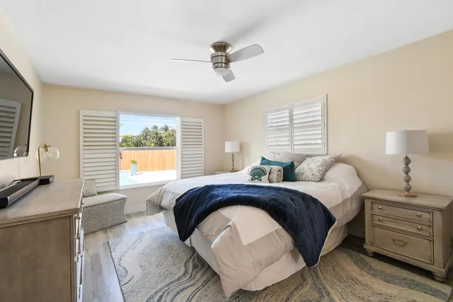 a spacious bedroom with a bed and a dresser next to a window
